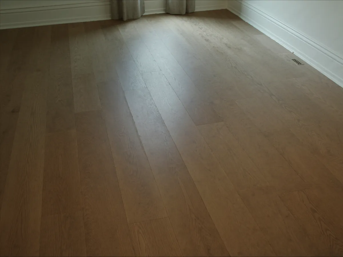 Wide engineered oak flooring running across an upstairs bedroom toward a curtained window